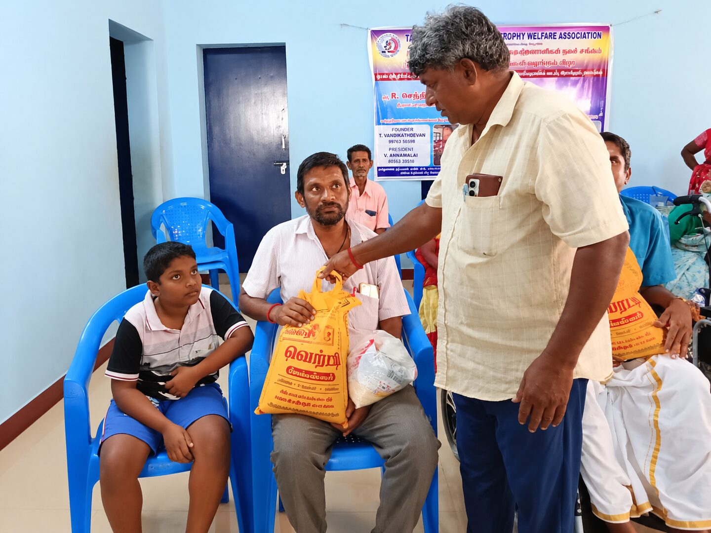 TNMDA volunteers handing provisions to a member at a community gathering