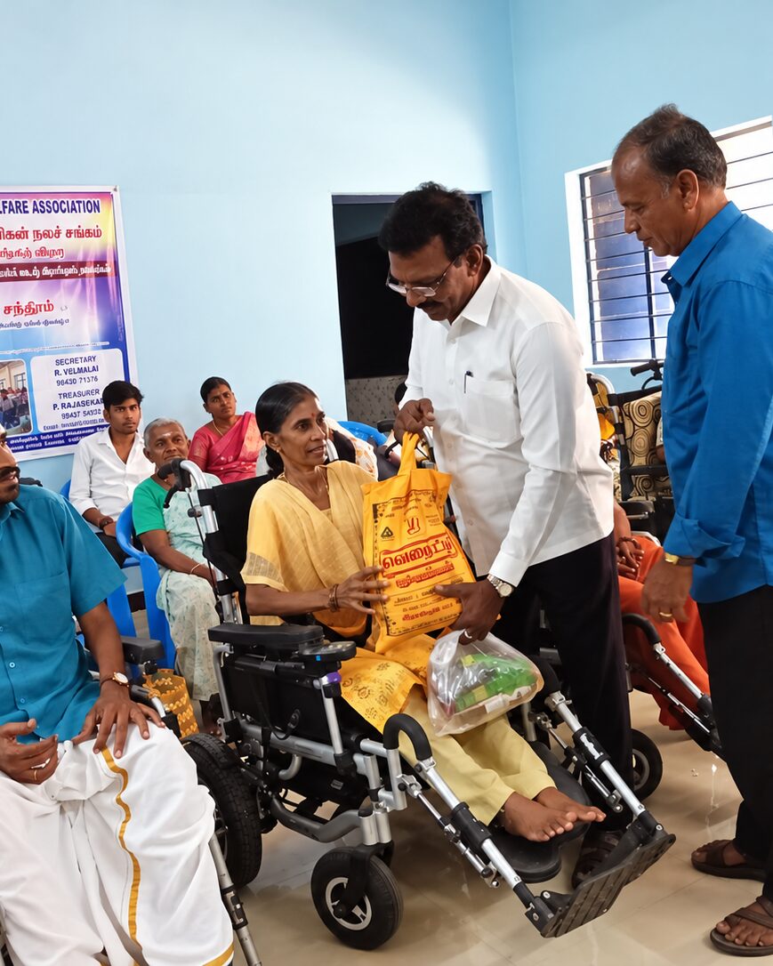 A TNMDA volunteer handing provisions to a member in a wheelchair