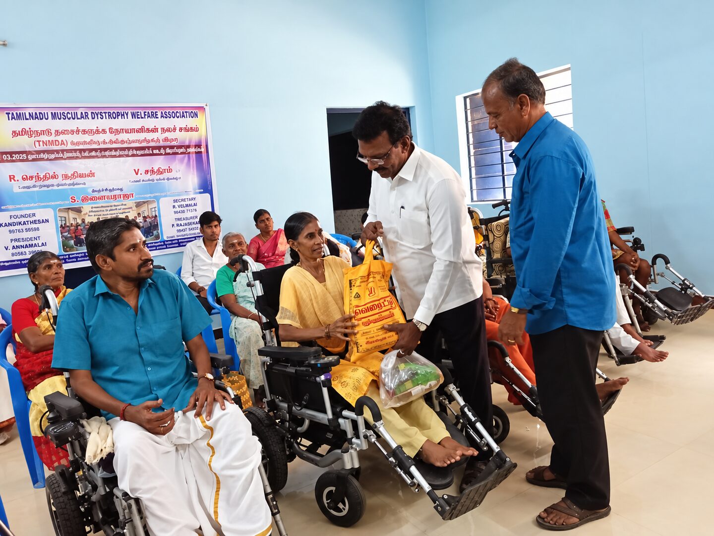 Two TNMDA volunteers distributing supplies to a family member